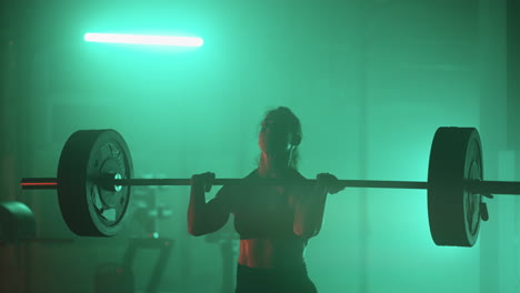 Slow-motion:-Athletic-Beautiful-Woman-Does-Overhead-Deadlift-with-a-Barbell-in-the-Gym.-Female-Professional-Bodybuilder-Workout-Weight-Lift-Exercises-in-the-Authentic-Sport-Training-Facility.